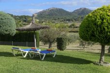 Zona chill out con hamacas, sombrilla y vistas a la montaña en Villa Catalina en Alcudia, Mallorca