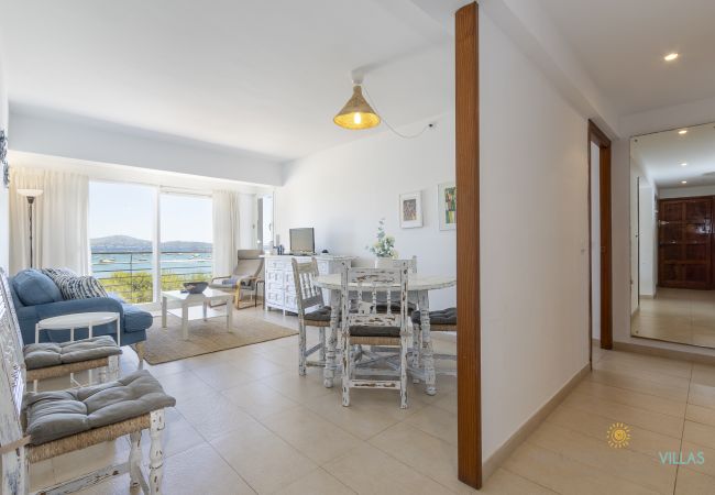 Salón-comedor con vistas al mar en Puerto de Pollensa Salón-comedor amplio con muebles blancos y vistas al mar en Pollensa