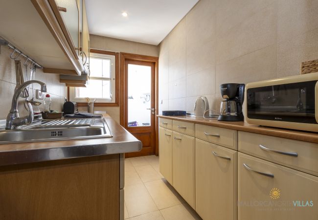 Cocina con acceso exterior y pequeños electrodomésticos Cocina completa con fregadero, horno, tostadora y cafetera