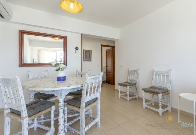 Comedor rústico de estilo mediterráneo en Puerto de Pollensa Comedor con mesa redonda y sillas blancas de madera en Pollensa