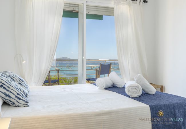 Dormitorio con vistas al mar en Puerto de Pollensa Cama doble junto a gran ventanal con vistas a la bahía de Pollensa