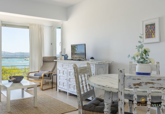 Detalle del salón-comedor con vistas al mar en Pollensa Comedor con mesa blanca rústica y vistas al mar en Puerto de Pollensa