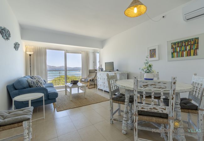 Salón-comedor con vistas al mar y decoración mediterránea Salón-comedor luminoso con muebles blancos y vistas al mar