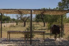 Terraza con mesa de bambú, pérgola y barbacoa en finca rural de Mallorca.