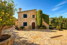 Finca tradicional en Pollença con fachada de piedra, patio y árboles frutales