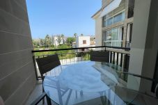 Terraza del Apartamento Llenaire en Port de Pollença con mesa exterior y vistas al jardín y la montaña.