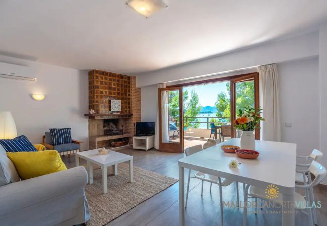 Wohn-Esszimmer mit Kamin und Blick – Puerto Pollensa Wohn-Esszimmer mit Kamin und Terrasse mit Meerblick in der Ferienwohnung Bel, Puerto de Pollensa