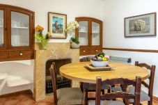 Dining room detail with stone fireplace and round wooden table in a Mallorcan village house