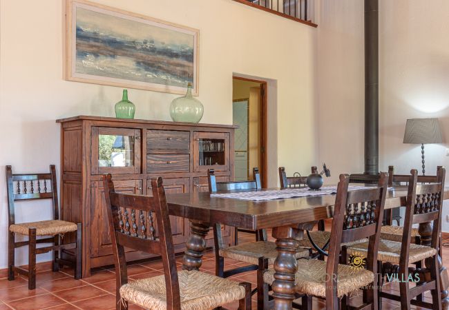 Rustic dining room with wooden table and wood stove Rustic dining room detail with wooden table, Mallorcan chairs and wood stove in Mallorca finca