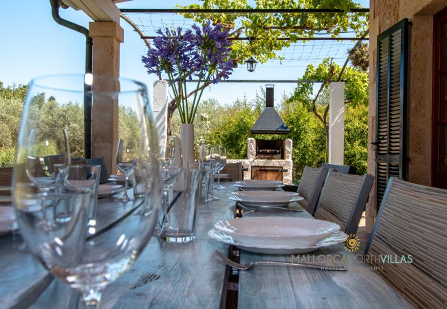 Outdoor terrace with dining and barbecue in Mallorca finca Set dining table on outdoor terrace with built-in barbecue in holiday finca Mallorca