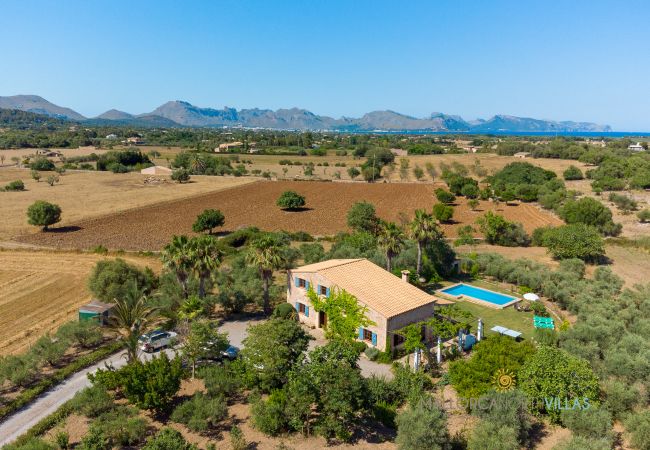 Panoramic view of stone finca with pool Panoramic view of the stone finca with private pool and rural surroundings with mountains in the background.
