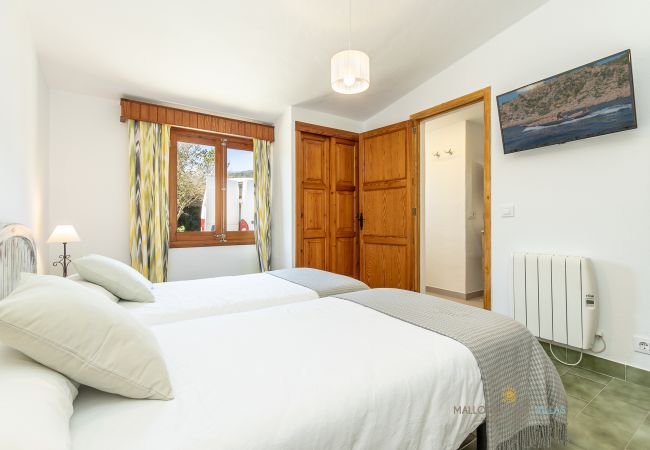 La Sort Llarga Double Bedroom – Two beds and window Pollença Bedroom with two single beds, window and wooden wardrobe at La Sort Llarga, Pollença