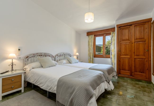 La Sort Llarga Double Bedroom – Two beds and wardrobe Pollença Bedroom with two single beds, wooden wardrobe and exterior window at La Sort Llarga, Pollença