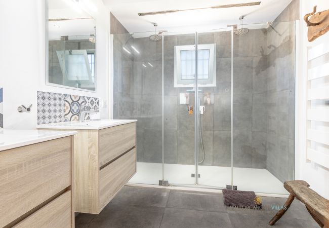 La Sort Llarga Bathroom – Modern glass shower in Pollença Bathroom with glass shower, wooden vanity and mirror at La Sort Llarga, Pollença