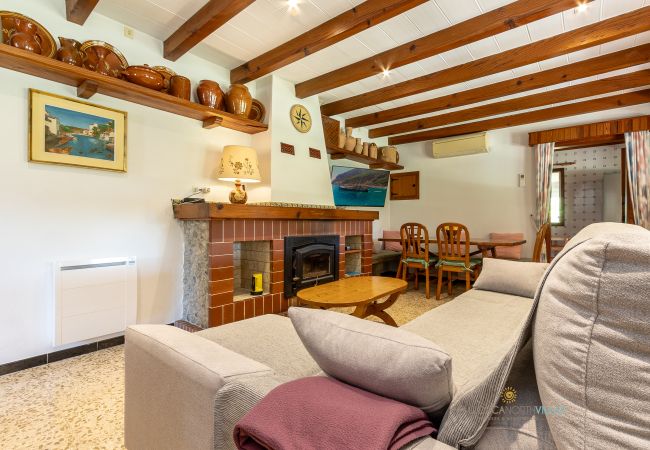 La Sort Llarga Living-Dining – Interior in Pollença Sofas, fireplace and dining table in the living room of La Sort Llarga, Pollença