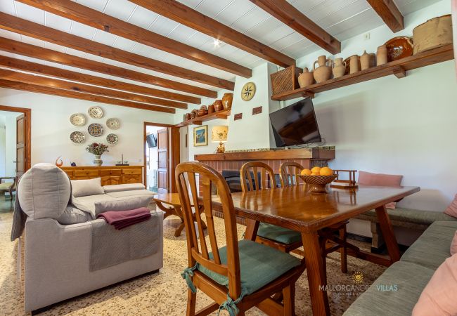La Sort Llarga Living-Dining – Table and sofas in Pollença Dining table and sofas in the living room with fireplace at La Sort Llarga, Pollença