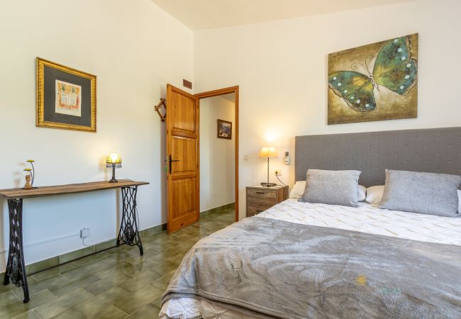 La Sort Llarga Bedroom – Double bed and console in Pollença Bedroom with double bed, nightstands, painting and console at La Sort Llarga, Pollença