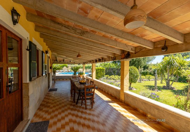 La Sort Llarga Exterior – Porch with dining area in Pollença Porch with dining table and garden views at La Sort Llarga, Pollença