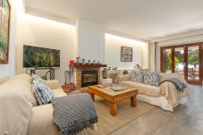 Living room with two sofas, wooden table, fireplace and terrace access.