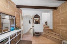 Entrance hall with stone walls, exposed beams and access to hallway and stairs.