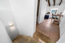 Espace à l’étage avec bureau, chaise et fenêtre apportant de la lumière naturelle.